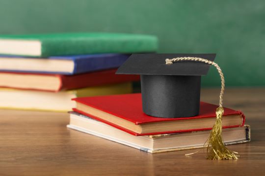 Image of graduation caps and books